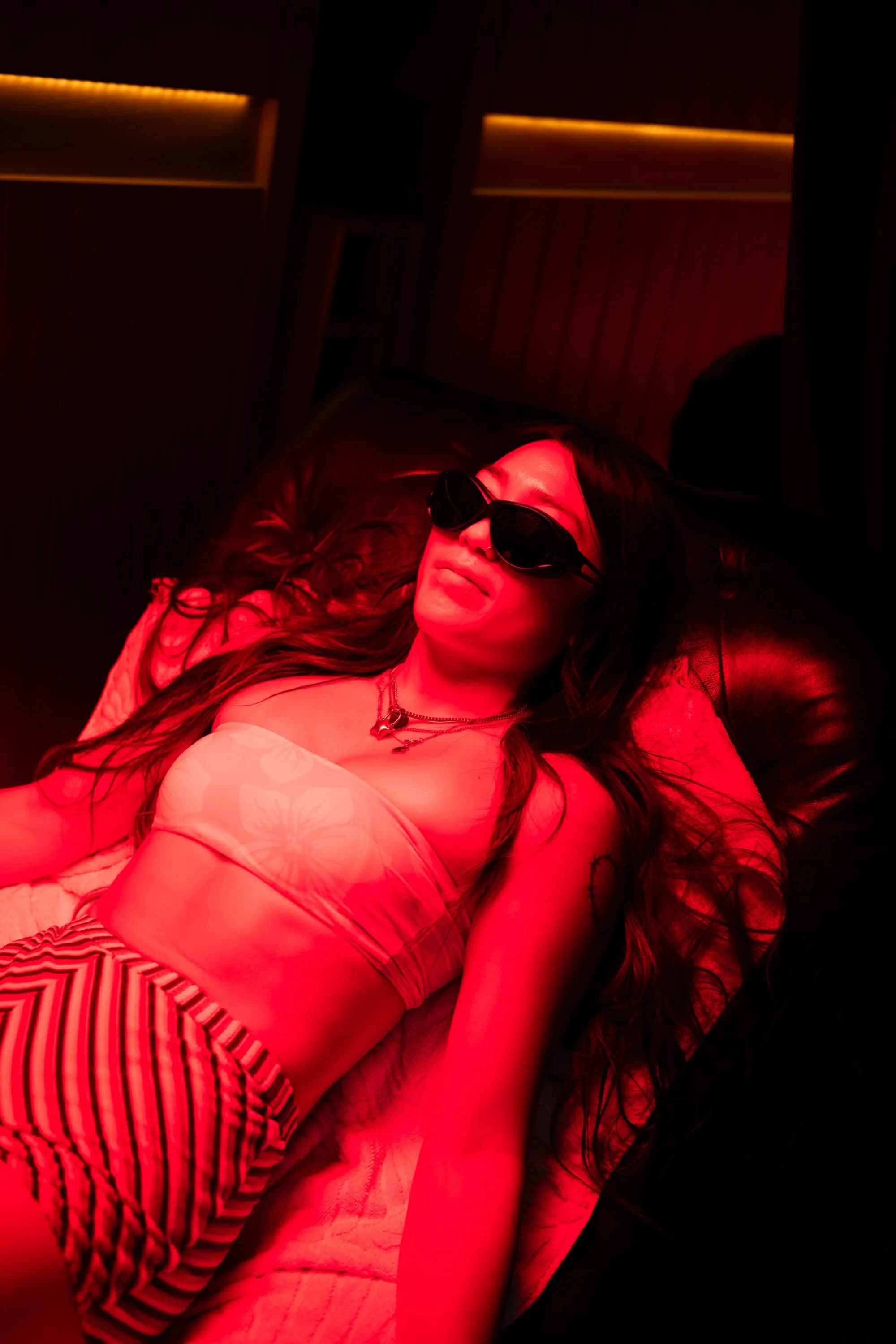 Guest relaxing under warm red light at the Club House ENC studio